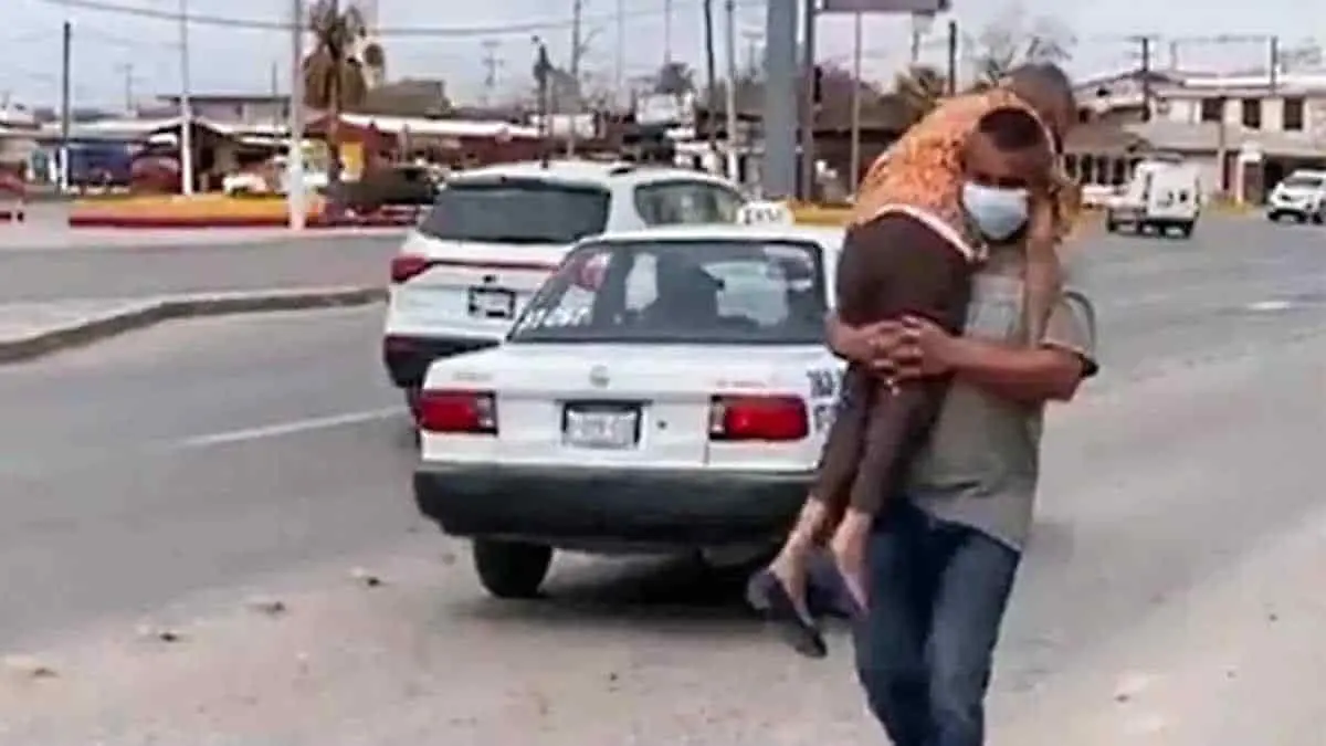 Lleva en brazos a su madre para que sea vacunada