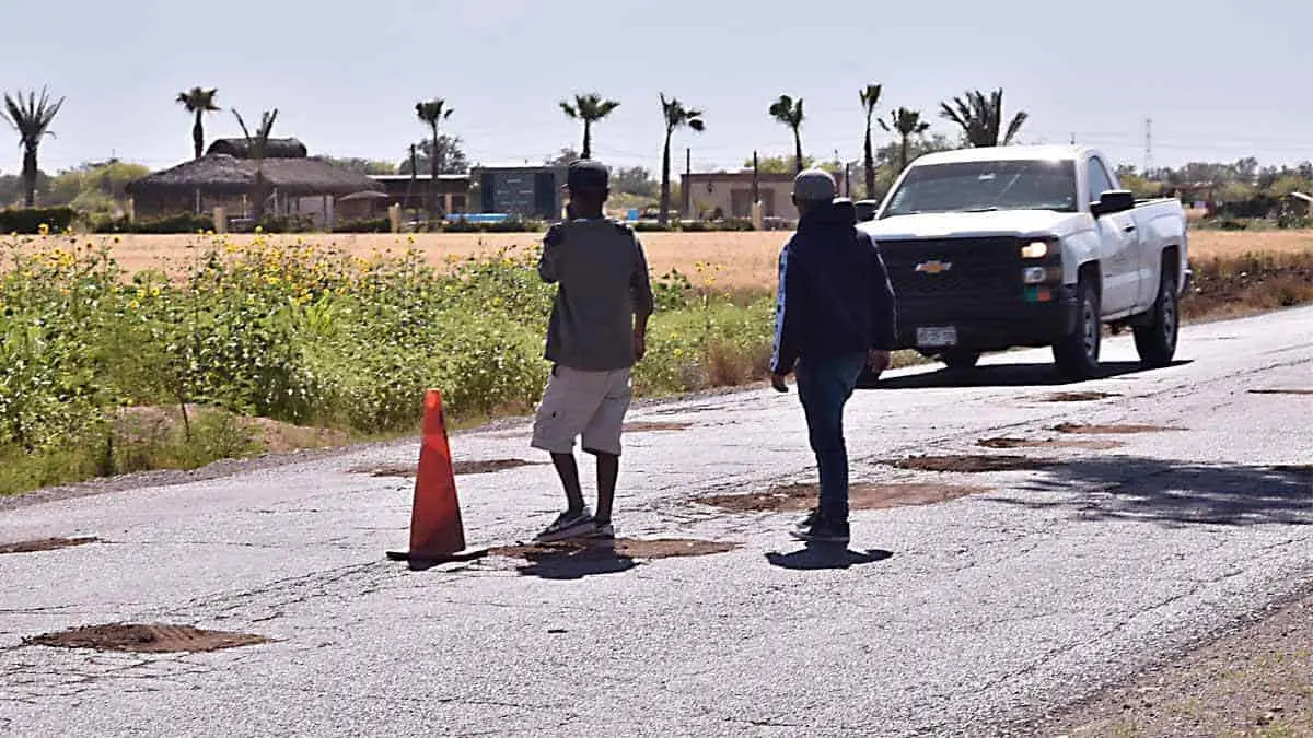Tapan con tierra los baches de caminos vecinales