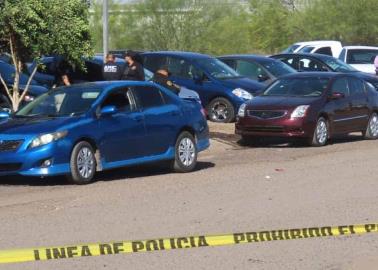 Acribillan a pareja en lote de carros; un joven muere