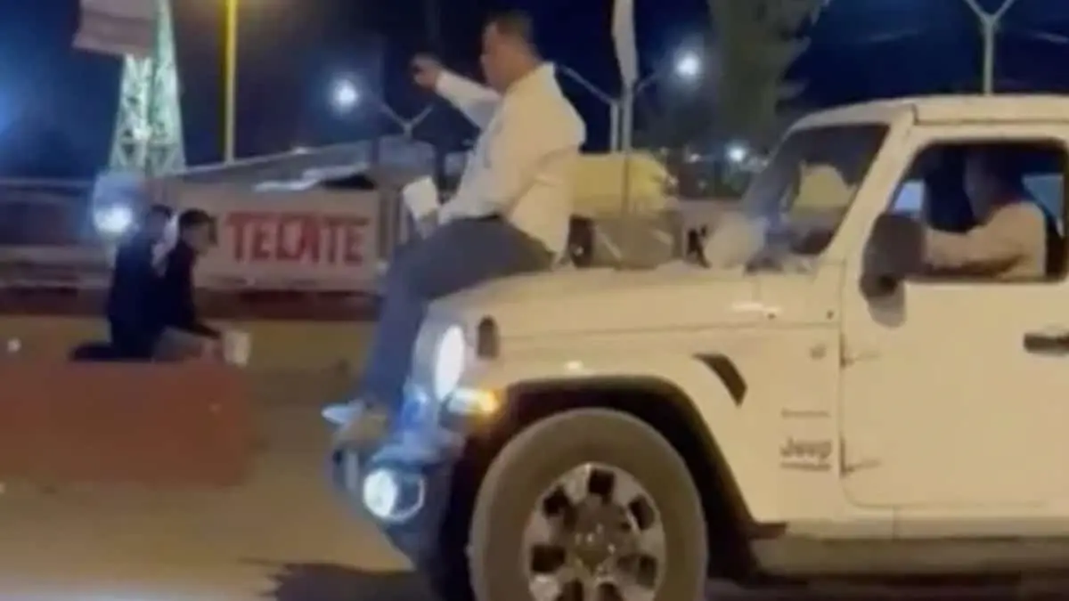 Alcalde pasea en el cofre de camioneta, con una bebida en la mano