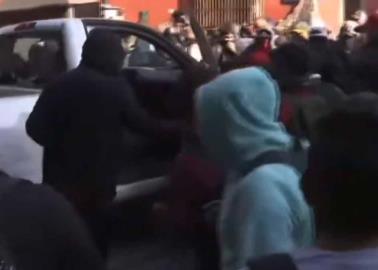 VIDEO | Padres de normalistas de Ayotzinapa derriban puerta de Palacio Nacional con auto de la CFE, en plena Mañanera