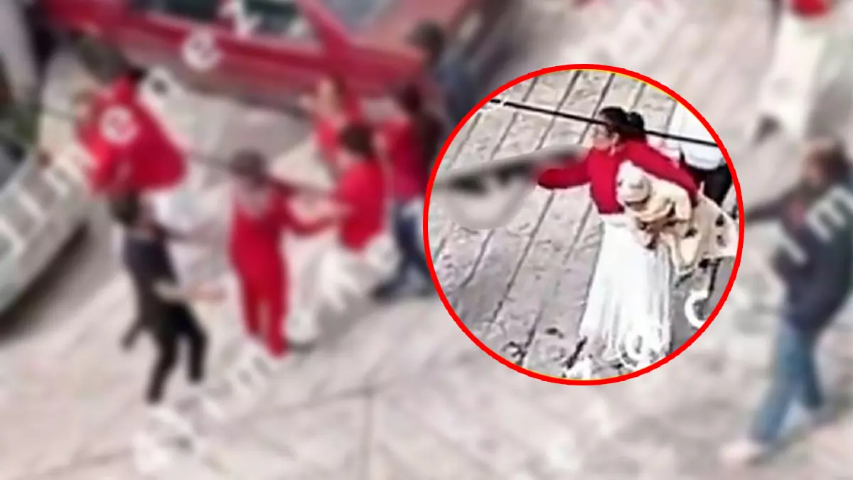 VIDEO | Mujer con bebé en brazo amenaza con arma larga en riña de vecinos